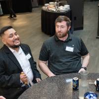Group of event attendees sitting at table and chatting